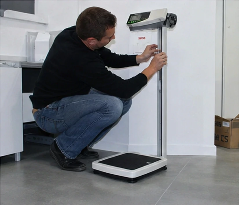 Homme travaillant sur un ordinateur portable devant un équipement de pesée